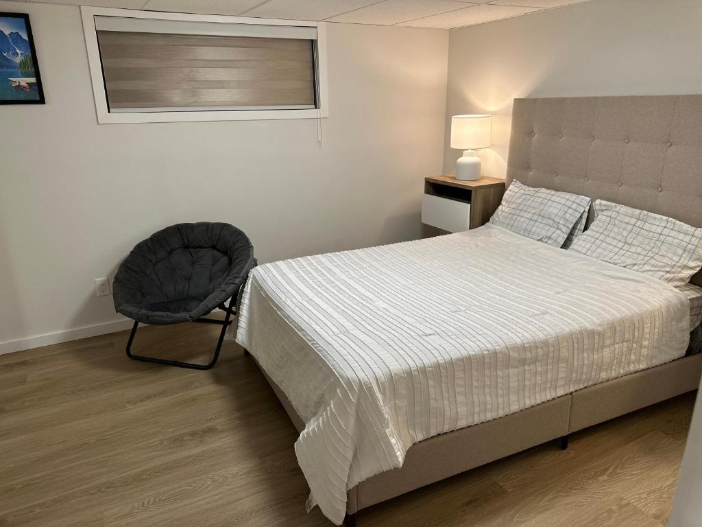 a bedroom with a bed and a chair at Guest expertise in Winnipeg