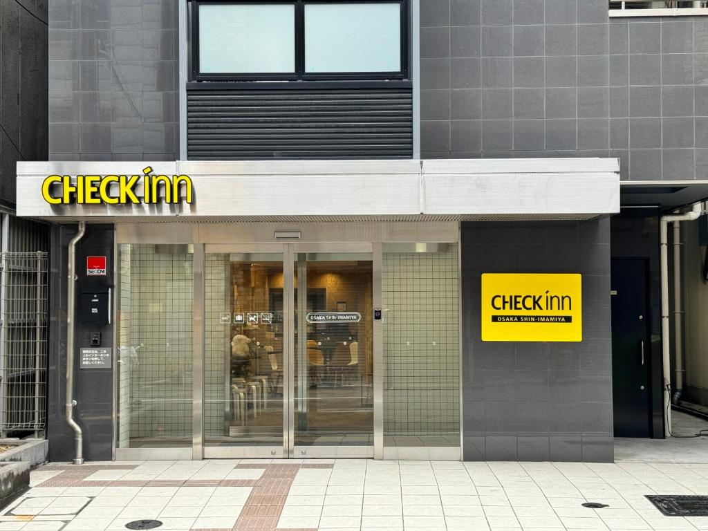 a building with a checkin sign on the side of it at CHECKinn Osaka Shinimamiya in Osaka