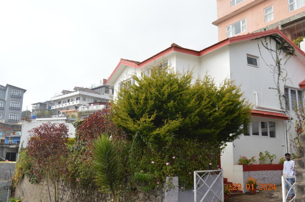 a man standing in front of a white house at Mystical Medows in Ooty