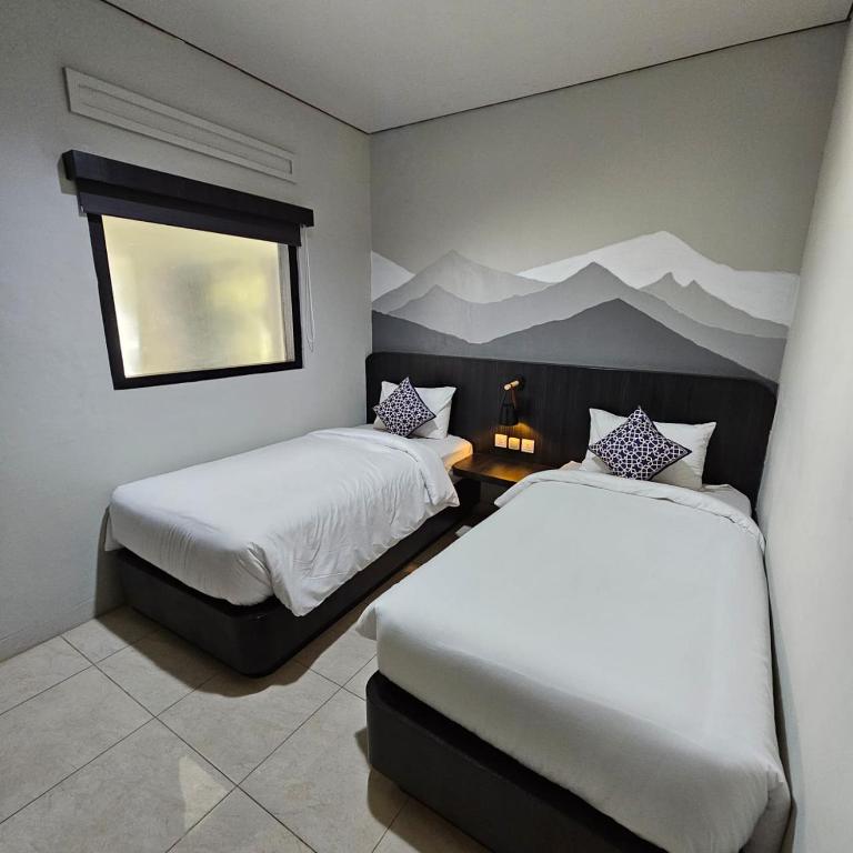 Postel nebo postele na pokoji v ubytování Airlangga Hotel