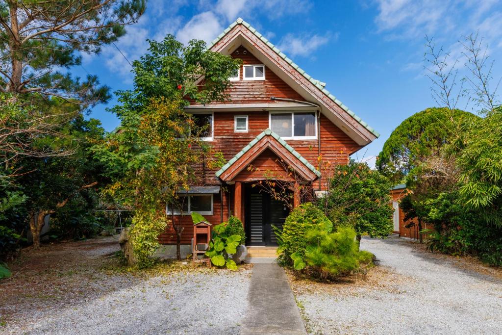 a red brick house with a driveway at Cottage Muinochichi in Motobu