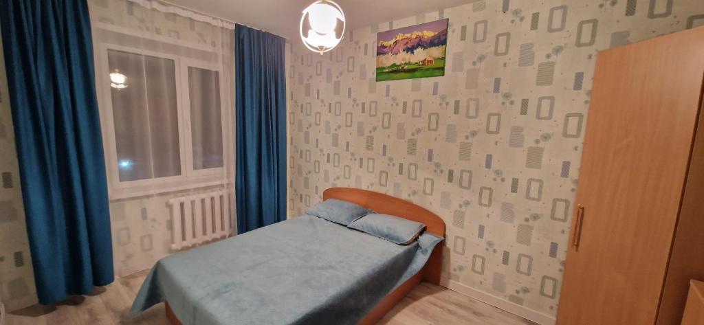 niewielka sypialnia z łóżkiem i oknem w obiekcie Двухкомнатная квартира на юго-востоке г.Караганда w mieście Karaganda