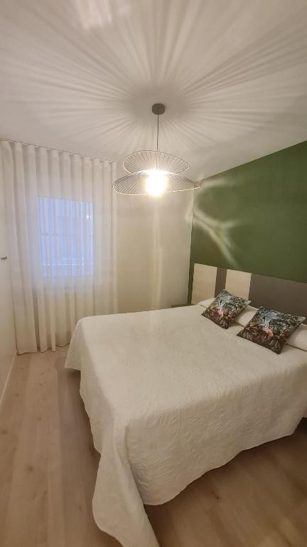 1 dormitorio con cama blanca y ventana en Casillas Bulevar, en Burgos
