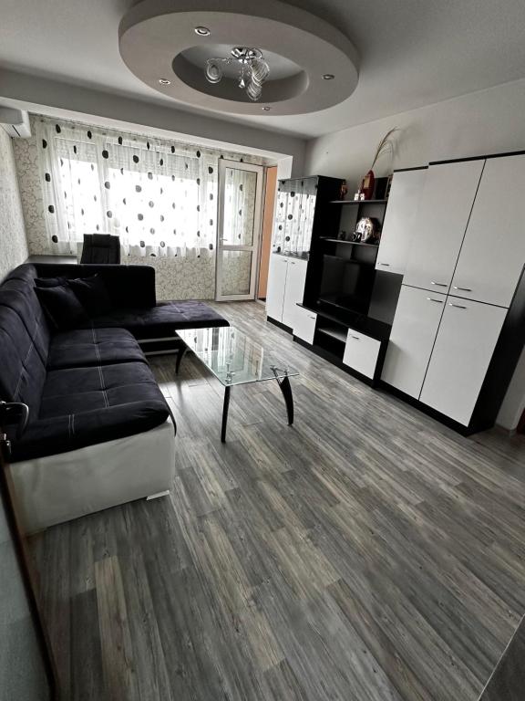 uma sala de estar com um sofá e uma mesa de vidro em KK Apartments em Stara Zagora