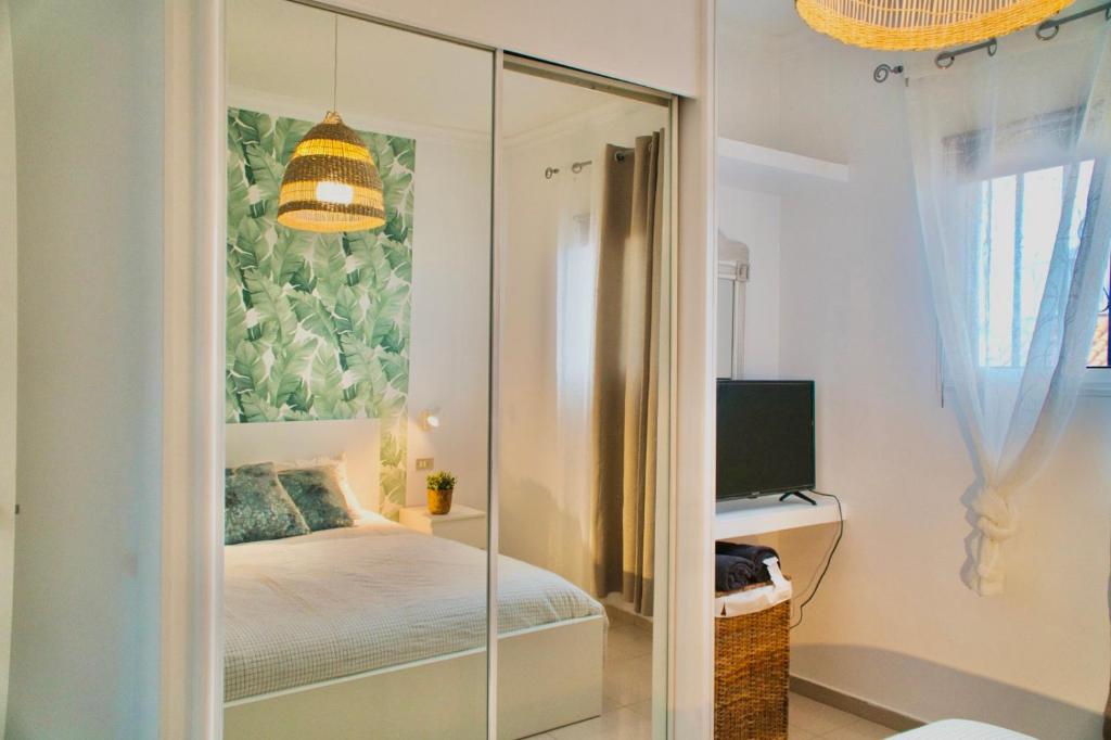 a bedroom with a glass door leading to a bed at Heart and Soul Apartment in San Miguel de Abona