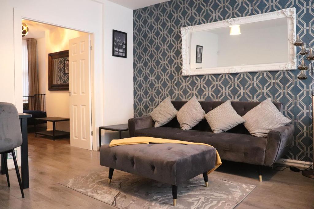 利物浦的住宿－Goodison Accommodation，客厅配有棕色的沙发和镜子
