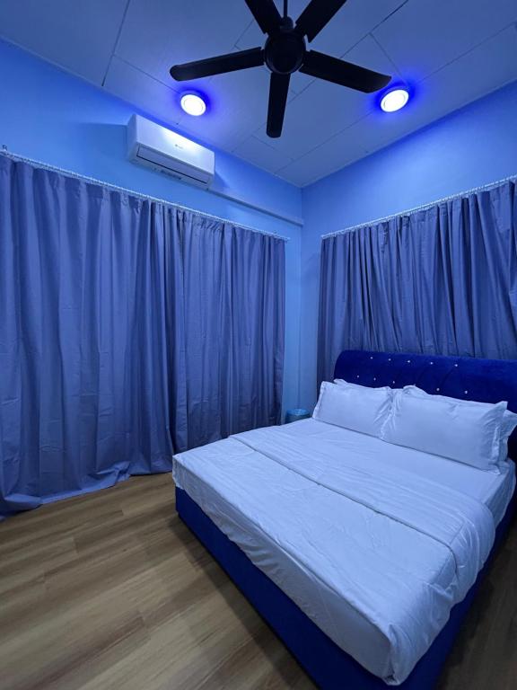 una camera blu con un letto e un ventilatore a soffitto di D’wokah Roomah Pool & Space a Ketereh