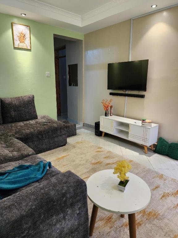 - un salon avec un canapé et une télévision dans l'établissement Wanderlust Haven, à Thika
