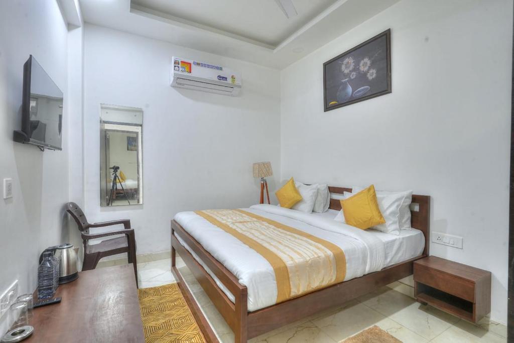 een slaapkamer met een bed, een bureau en een televisie bij icyhotels ncr international in Noida