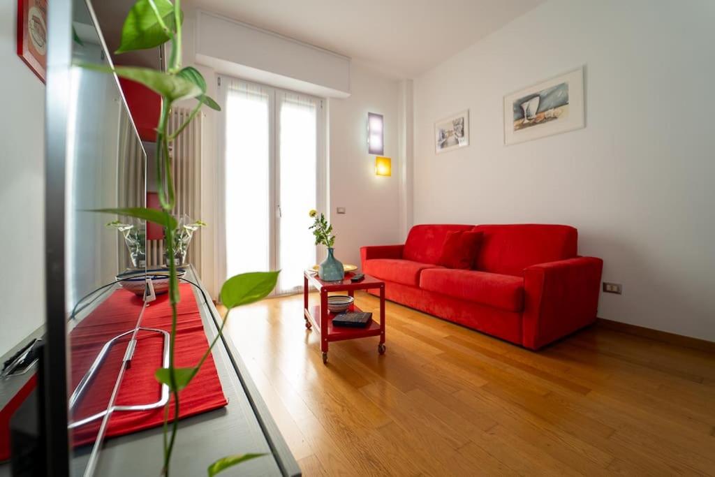 a living room with a red couch and a table at appartamento a 500 metri da San Siro in Milan
