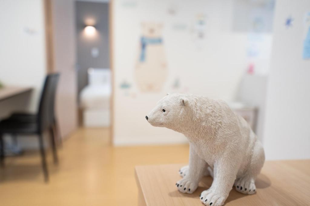 un orso polare bianco imbottito seduto su un tavolo di The Peak Villa Suite Hokkaido a Higashikawa
