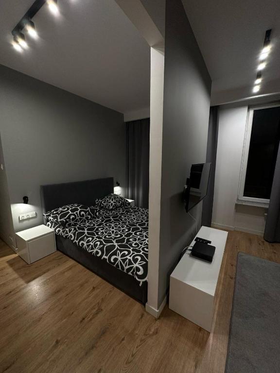 sypialnia z czarno-białym łóżkiem i telewizorem w obiekcie LubMarex1 Sławińska 508 w Warszawie