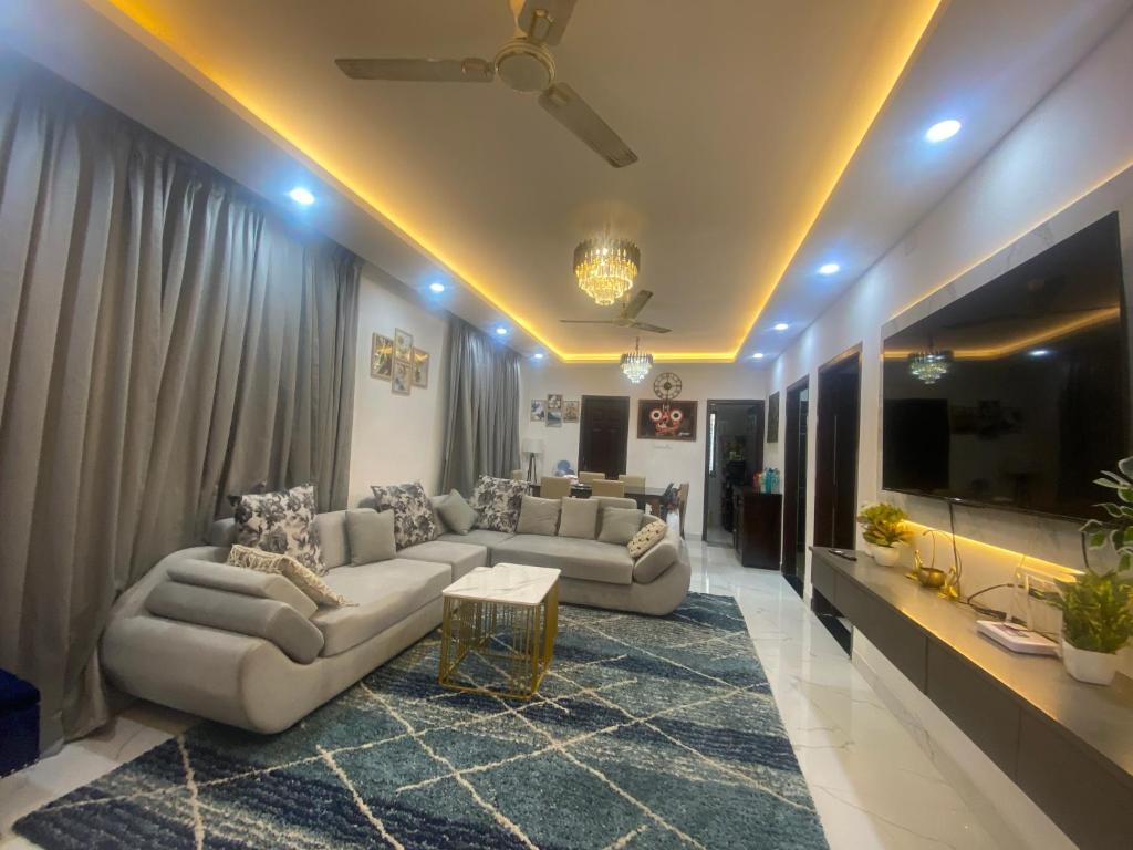 uma sala de estar com dois sofás e uma televisão em Krishna Villa em Bhubaneshwar