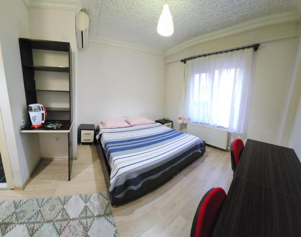 1 dormitorio con 1 cama, mesa y sillas en Balıkesir karesi grup konaklama ve pansiyon, en Balıkesir