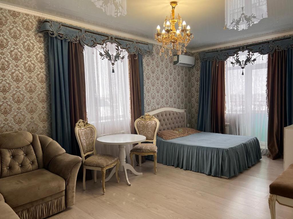 a bedroom with a bed and a table and chairs at Гостинично-банный комплекс Майами Люкс in Kostanay