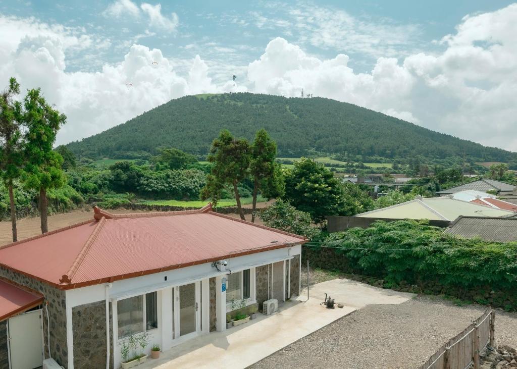 een huis met een berg op de achtergrond bij Moseul Jeju in Jeju-stad