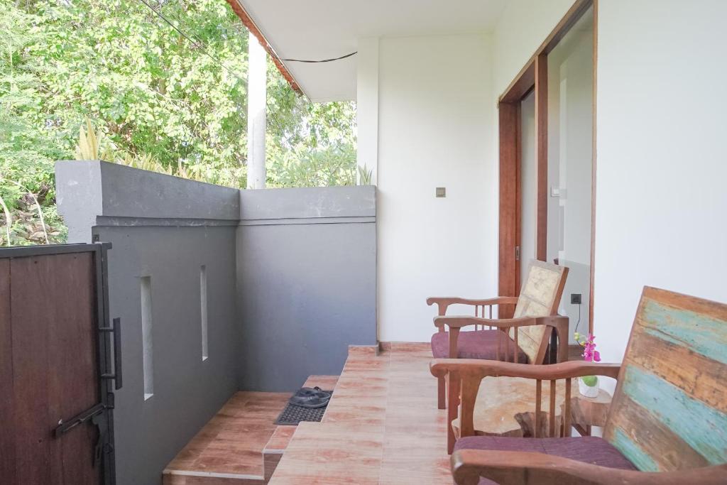 eine Veranda mit zwei Stühlen und einem Fenster in der Unterkunft Rumah Kecil Sanur in Sanur