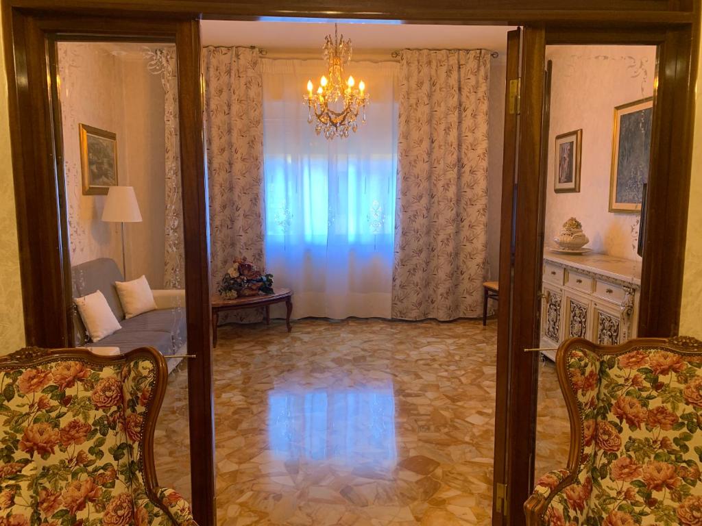 un soggiorno con divano e lampadario pendente di MAISON IVA & GIO' OLD STYLE a Genova