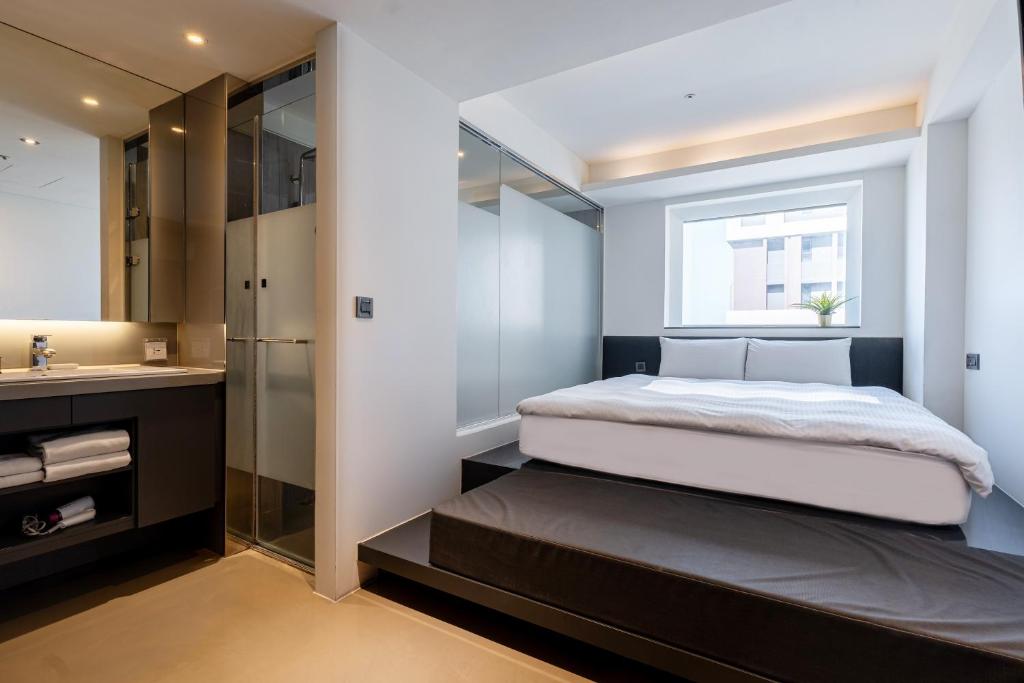 a bedroom with a large bed and a bathroom at CHECK inn Taichung Liming in Taichung