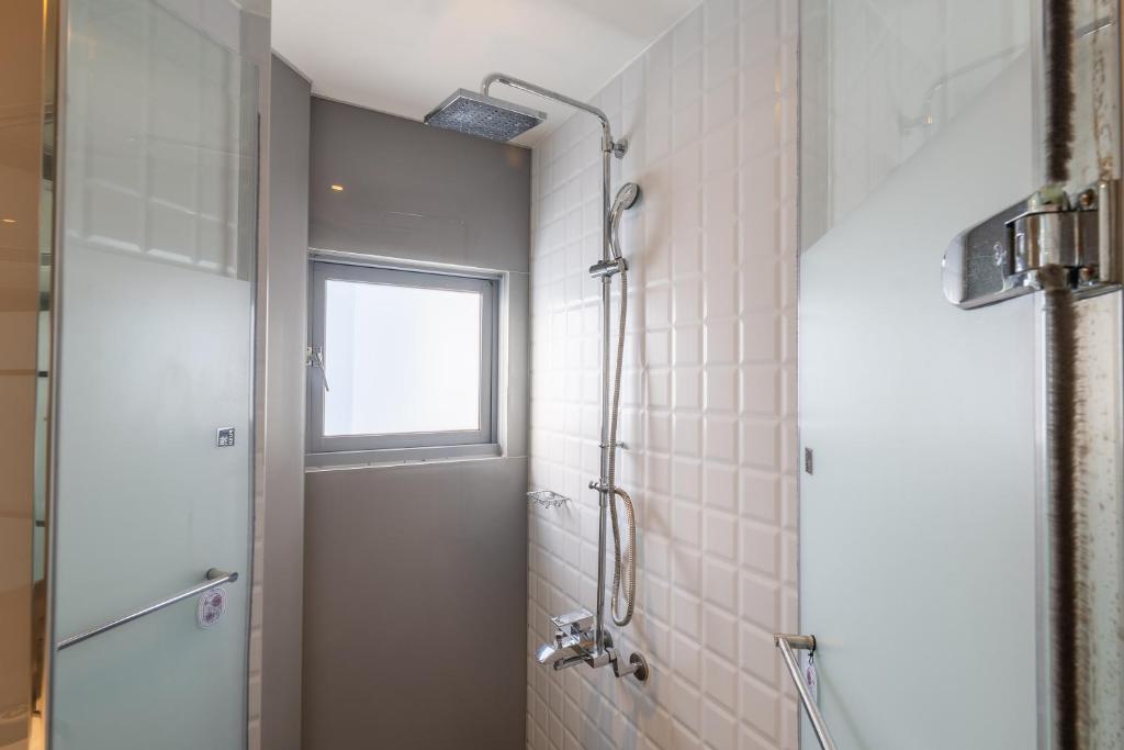 a bathroom with a shower and a window at CHECK inn Taichung Liming in Taichung