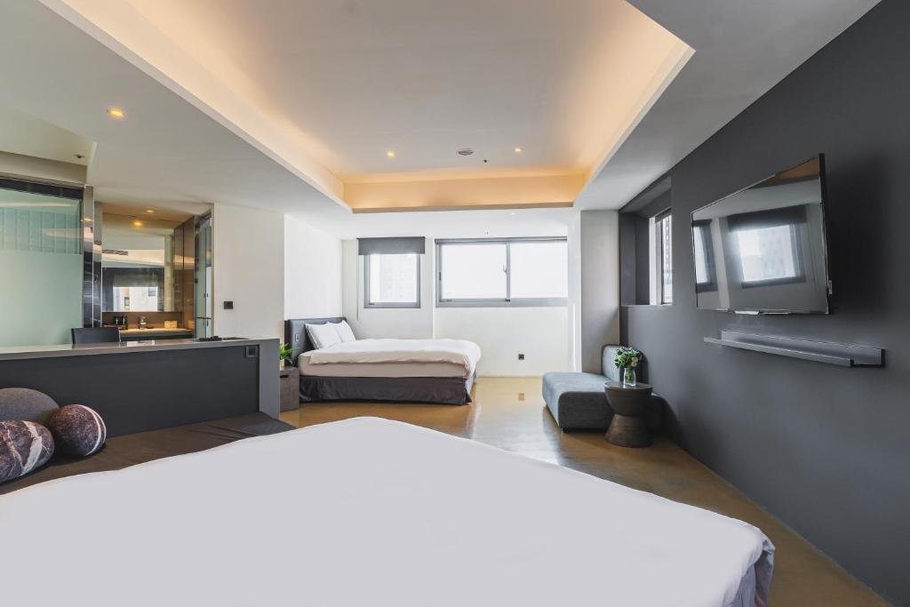 a bedroom with two beds and a kitchen at CHECK inn Taichung Liming in Taichung