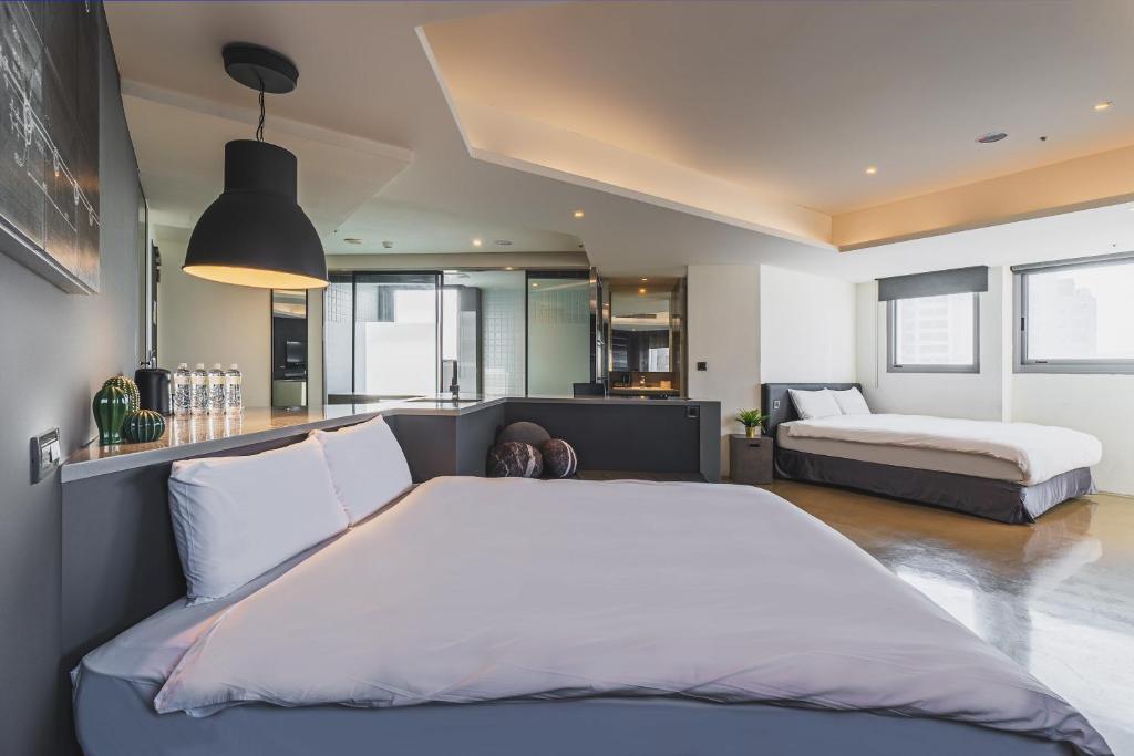 a bedroom with a large white bed and a couch at CHECK inn Taichung Liming in Taichung