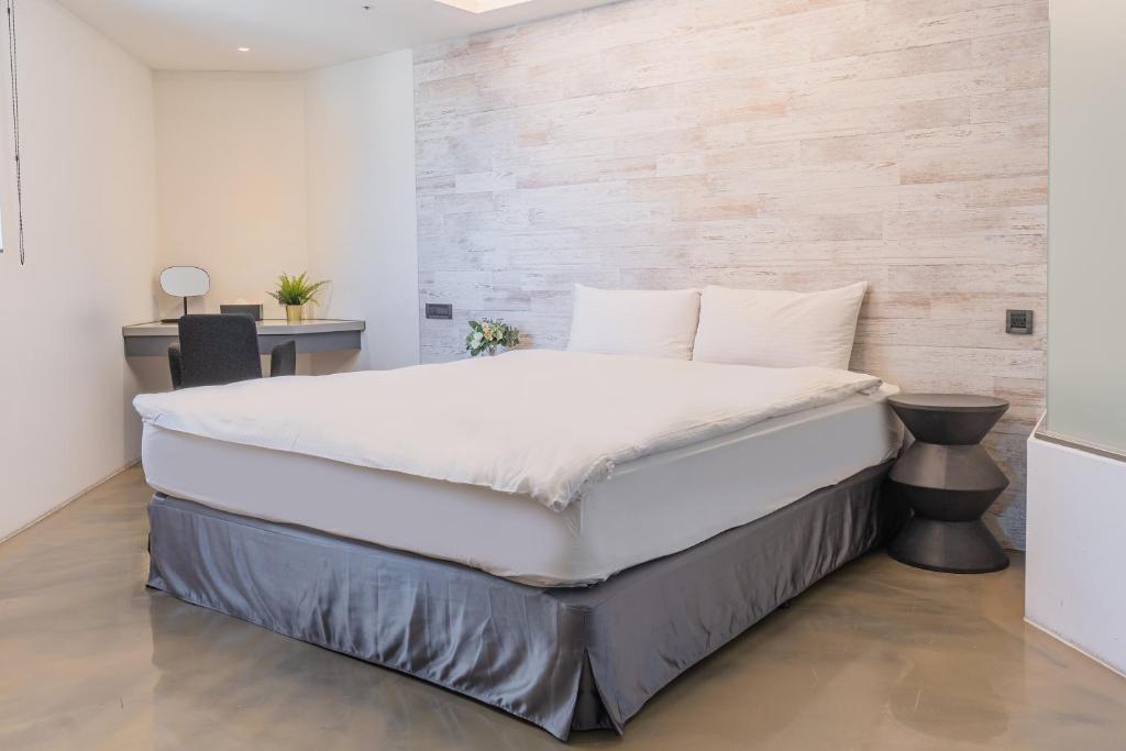 a large bed in a bedroom with a wooden wall at CHECK inn Taichung Liming in Taichung
