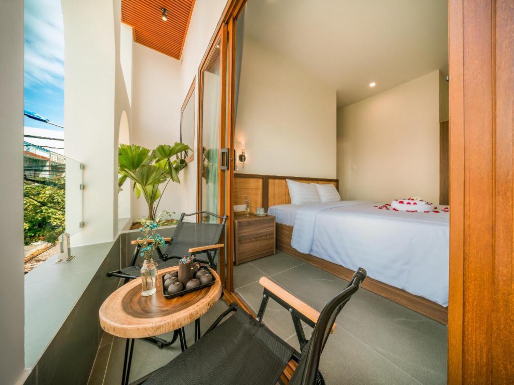 1 dormitorio con 1 cama, mesa y sillas en De V’Charm Hotel en Ðông Tác (1)