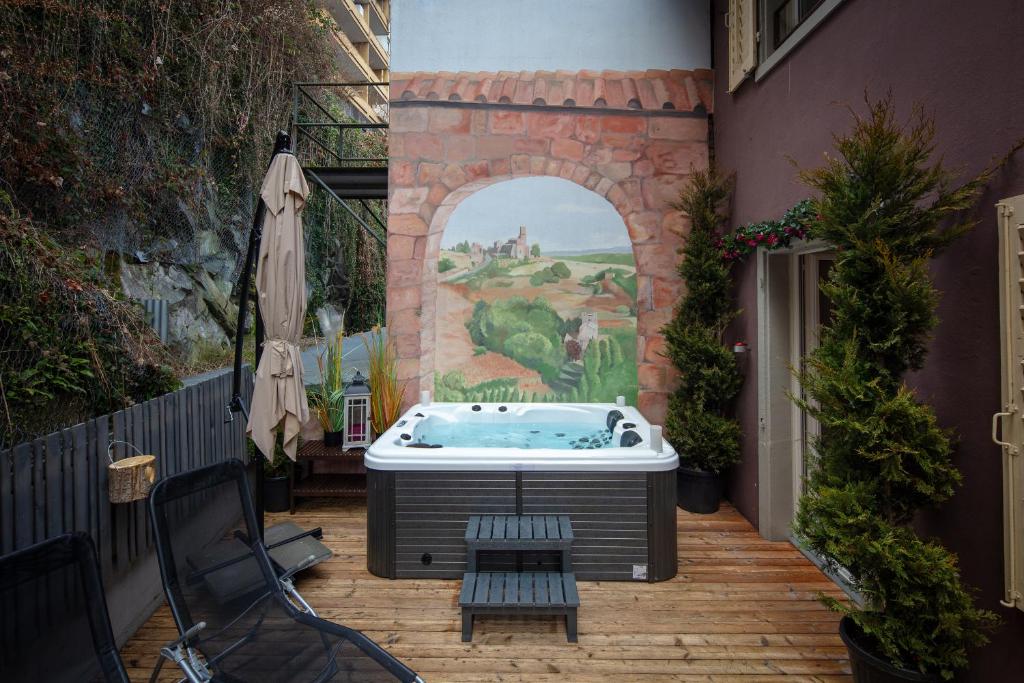 una bañera de hidromasaje en un patio con un mural en WELCOME APARTMENTS - Luzern, en Lucerna
