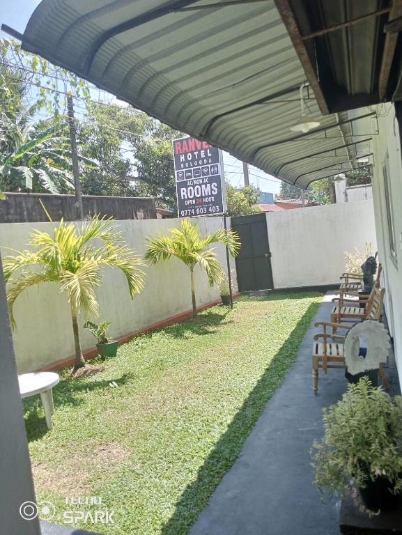 a patio with tables and chairs and a sign at Ranven hotel dampe in Piliyandala