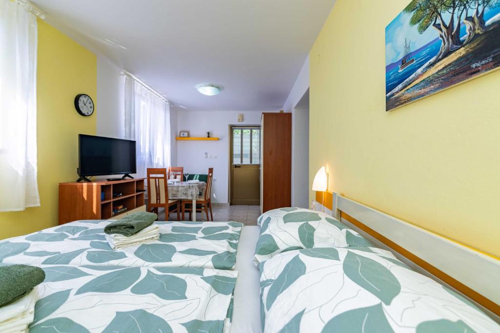 1 dormitorio con cama, mesa y TV en Apt ANA, Vantacici-Malinska, Island Krk, en Vantačići