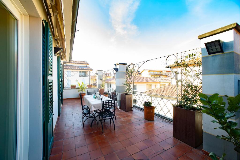 een patio met een tafel en stoelen op een balkon bij DIMORA STORICA VICOLO DEL VOLTO in Iseo