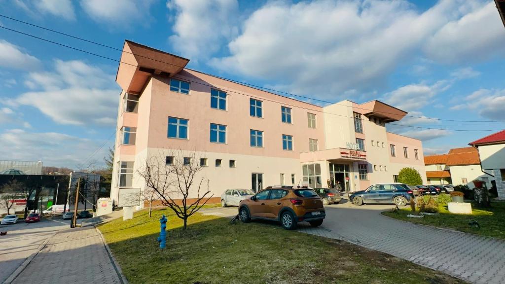 a building with a car parked in front of it at HOTEL MINERO in Tuzla