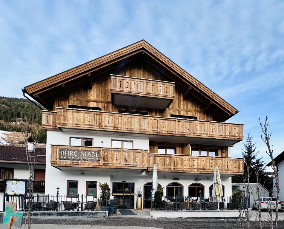 a large wooden building with a balcony at Burgstadl Aparthotel & Restaurant in Ladis