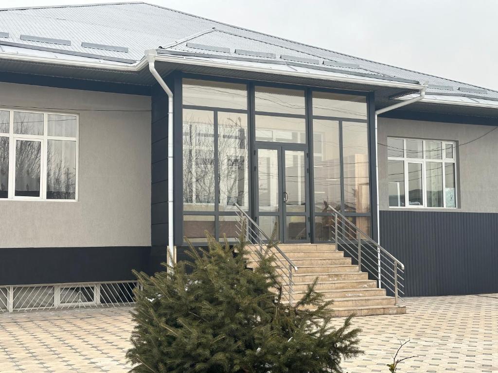 una casa con puertas de cristal y una escalera en Sunny Hostel, en Osh