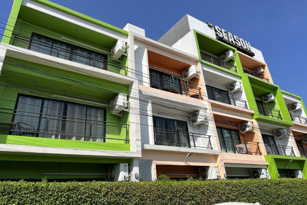 un edificio de apartamentos con zonas verdes y blancas en The Season Airport Udonthani, en Udon Thani
