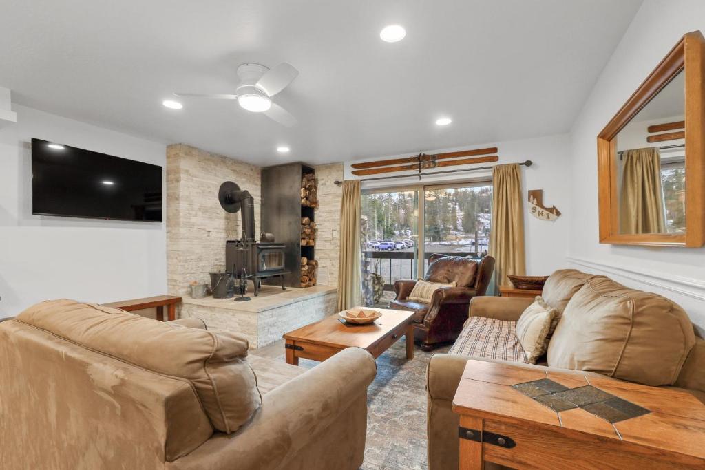 sala de estar con 2 sofás y TV en Luxury at Altitude – Base Camp 2 Bedroom condo, en Kirkwood