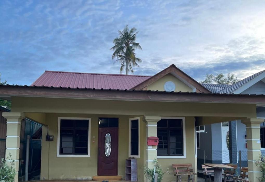 een klein geel huis met een paars dak bij Teratak Zaa D’Homestay in Kota Bharu