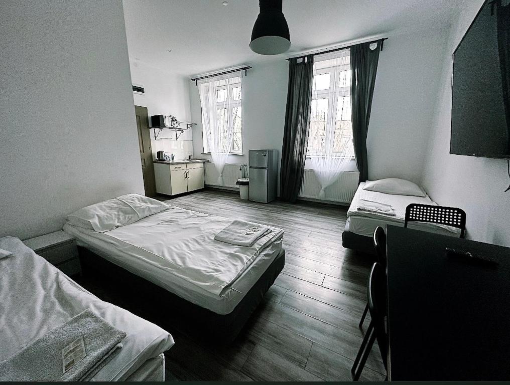a room with two beds and two windows at Apartamenty Retro in Dąbrowa Górnicza