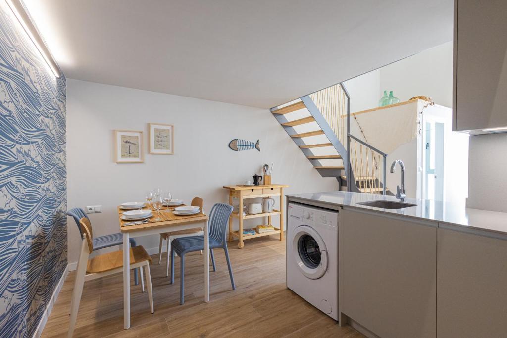 cocina y comedor con mesa y lavadora en FLORIT FLATS - The Seagull Apartments en Valencia