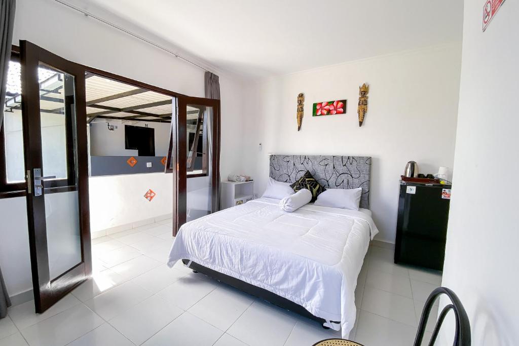 Postel nebo postele na pokoji v ubytování Kana Guest House Mitra RedDoorz