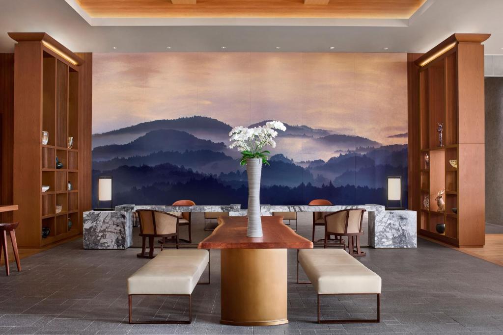 JW Marriott Hotel Nara في نارا: غرفة طعام مع طاولة مع إناء من الزهور