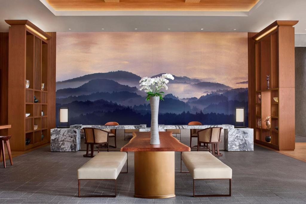 a dining room with a table with a vase of flowers at JW Marriott Hotel Nara in Nara