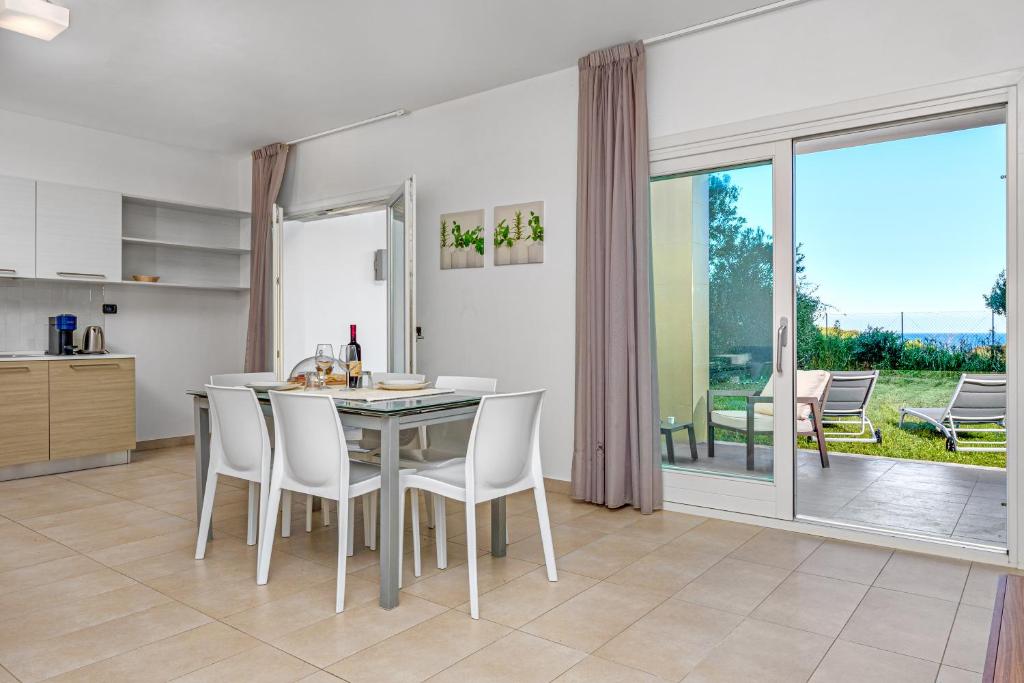 una cucina e una sala da pranzo con tavolo e sedie di Villa Marconi Apartment 5 a Golfo Aranci