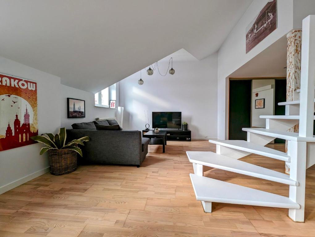 a living room with a couch and a stair case at Starowiślna 34 by Homeprime in Krakow