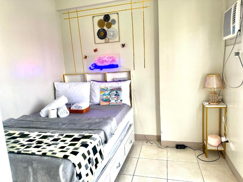 a bedroom with a bed with a black and white comforter at KenZel Staycation in Manila