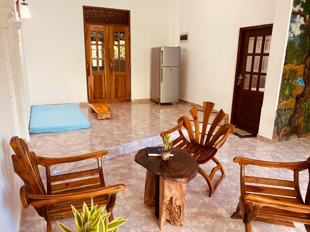 una camera con sedie, tavolo e frigorifero di Dream Villa a Matara