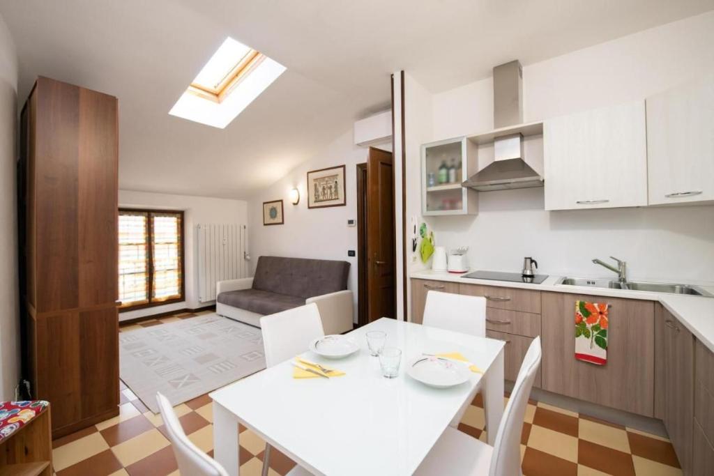 eine Küche und ein Wohnzimmer mit einem weißen Tisch und Stühlen in der Unterkunft Casa Marisa sul Garda in Toscolano-Maderno