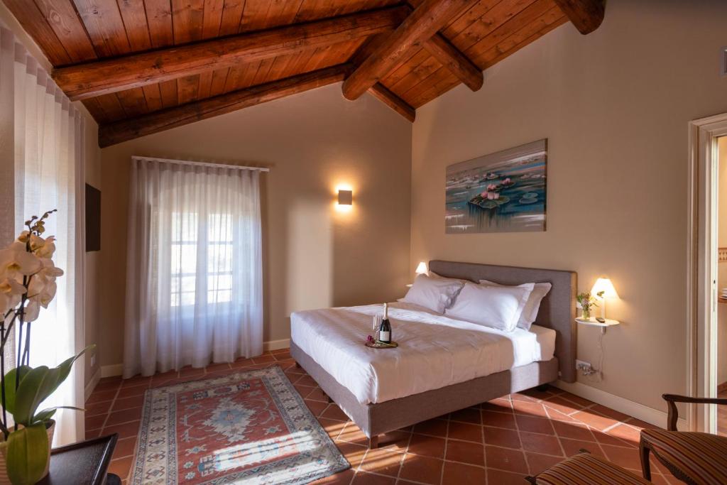una camera con letto in una stanza con soffitti in legno di Agrisuite Le Querce del Vareglio a Canale