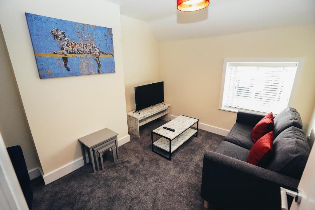 a living room with a couch and a tv at The Stay Company, Friar Gate Bridge. in Derby